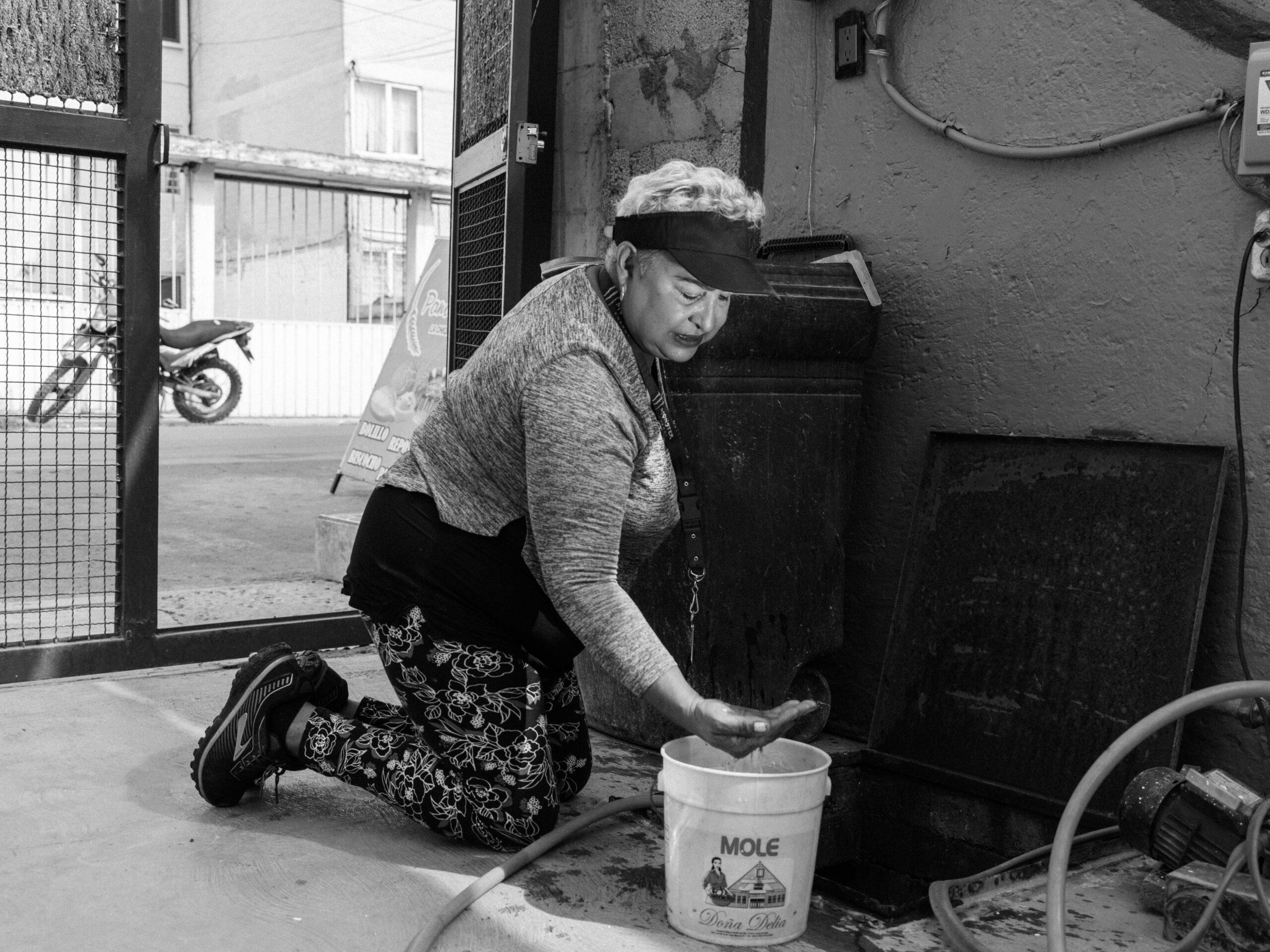 Norma, 68 years old, collects unfiltered, nonpotable water from a well in her yard in Ecatepec, Mexico, May 9, 2024.