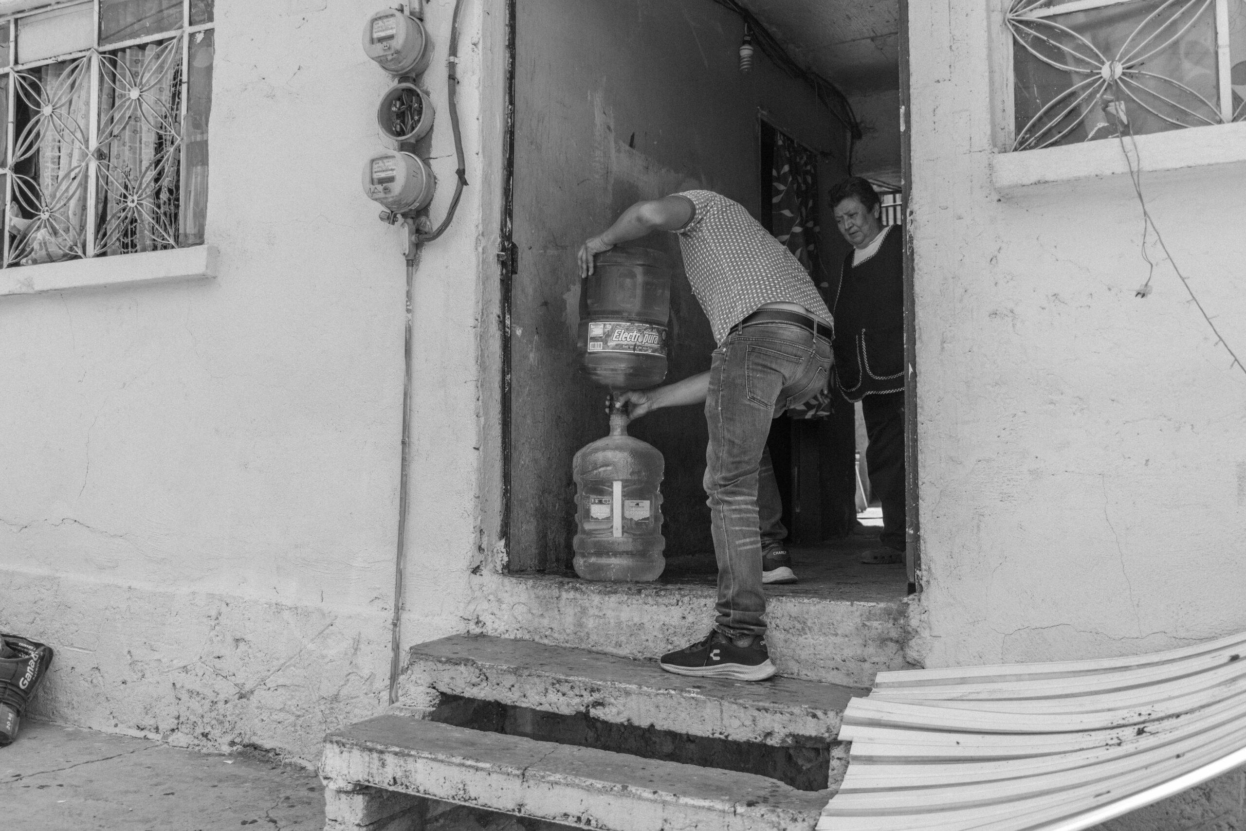A resident of Naucalpan receives drinking water, transferred into the empty container that each resident keeps, May 25, 2024.